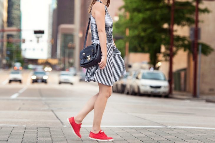 Caroline Harper Knapp of HOUSE of HARPER styles a navy stripe dress with a baseball cap and red tennis shoes.