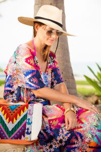 Caroline Knapp of HOUSE of HARPER wears a colorful kaftan on the beaches of Tulum.