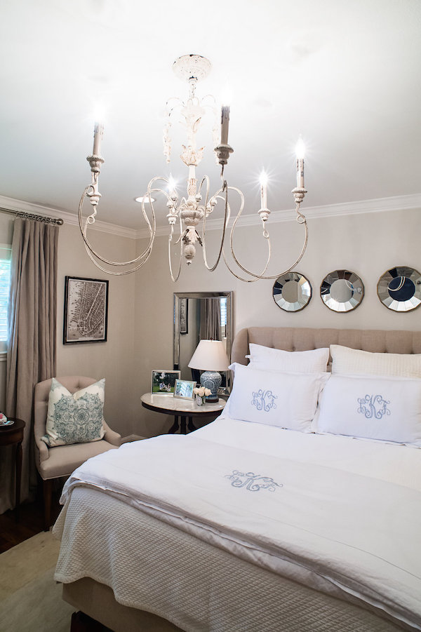 A calming neutral bedroom with antique furniture and blue accents.