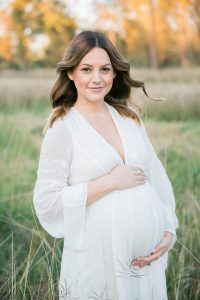 white dress in a field maternity pictures