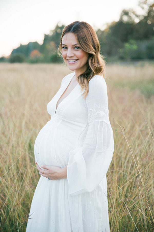 white dress in a field maternity pictures